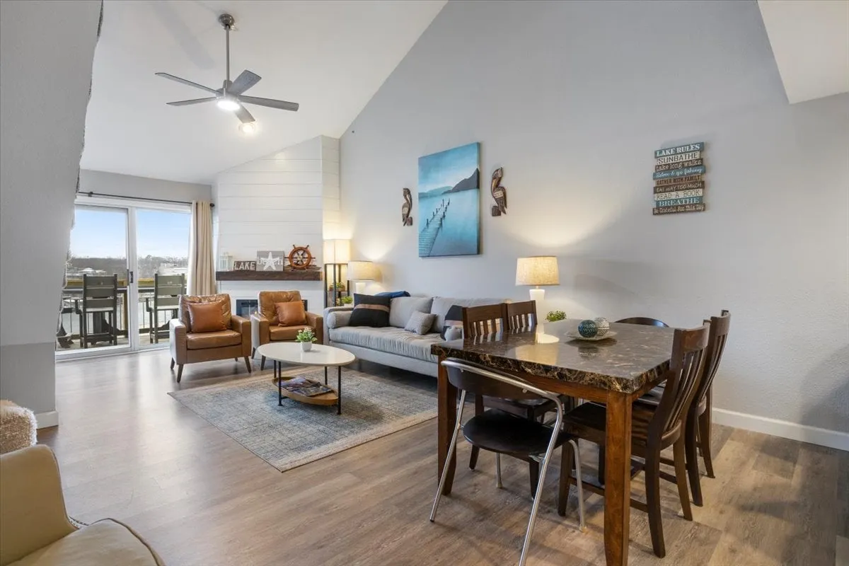 An open-concept area that seamlessly transitions between a plush sofa, a spacious dining table, large windows, and stylish wall art. The layout encourages both lively social gatherings and quiet moments, offering flexibility for group meals, conversations, or games.