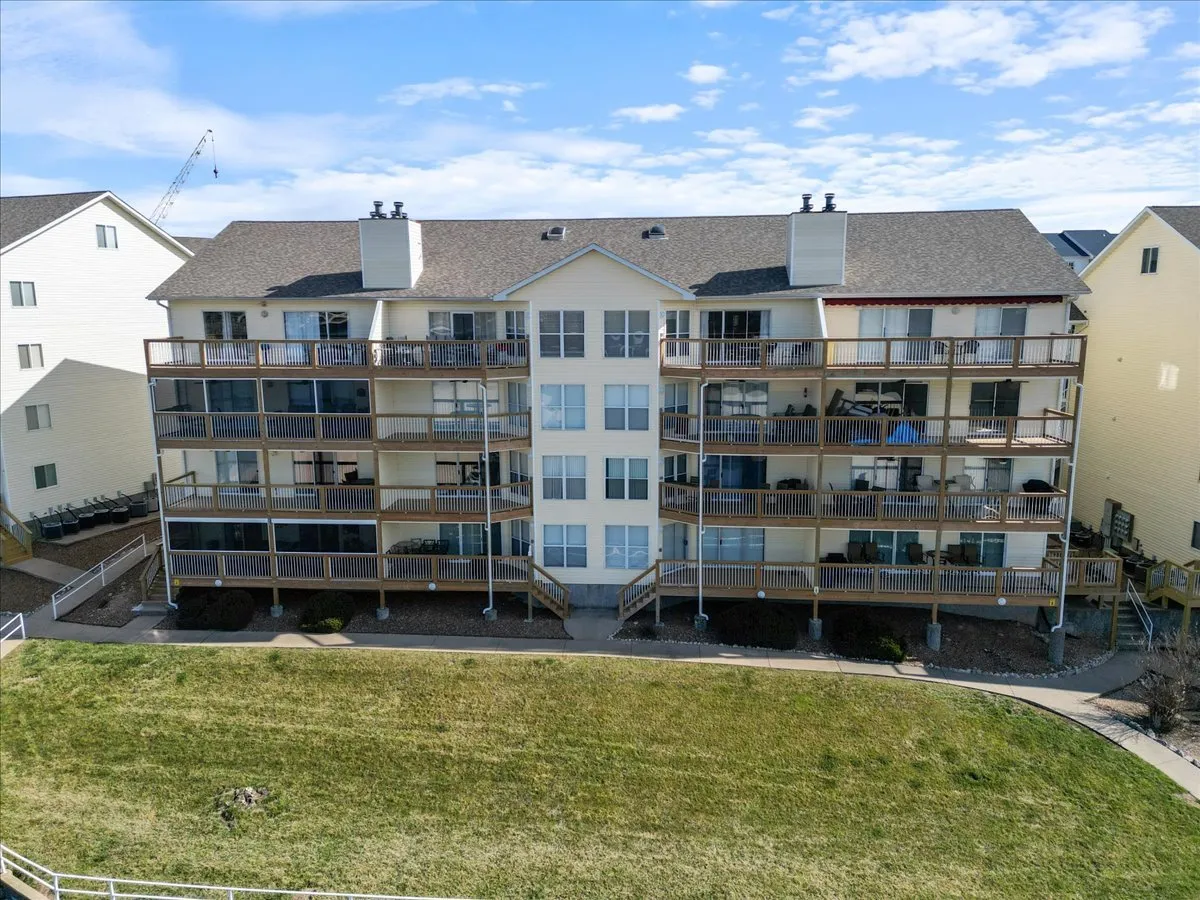 The exterior of the condo building, featuring welcoming balconies, large windows, and landscaped grounds. The balconies offer a glimpse of the scenic views available to guests, connecting the indoors with the outdoors.